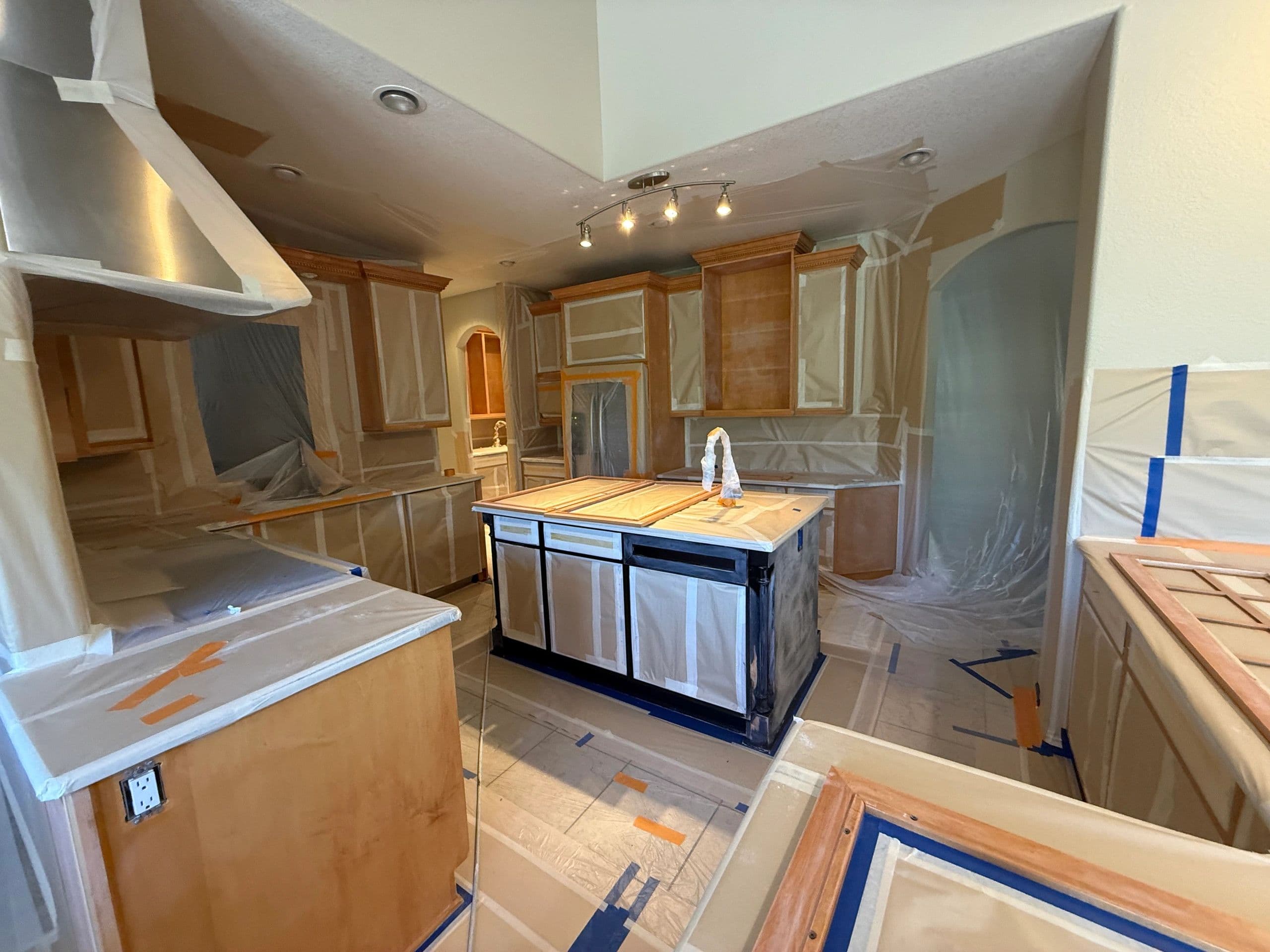 Kitchen fully masked in plastic and tape before painting